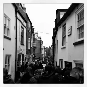 A very busy black and white image of Whitby High Street 